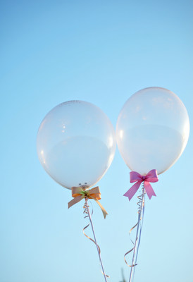 Colorful balloons floating under a clear blue sky