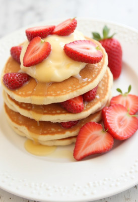 Delicious pancakes with fresh strawberries and syrup