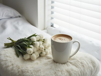 Cozy morning with coffee and fresh flowers by the window