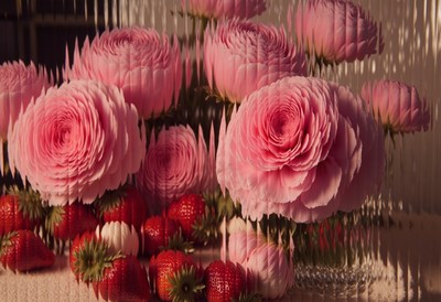 Fresh pink roses and strawberries create a vibrant display