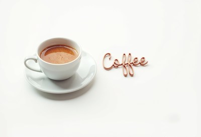 Coffee cup with a creative text arrangement beside it