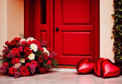 Romantic floral arrangement with heart balloons at doorway