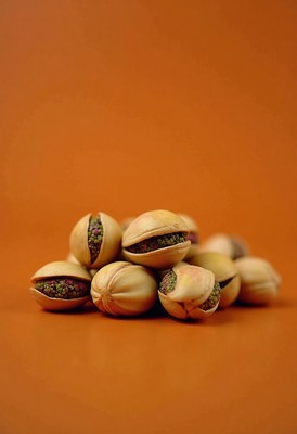 Textured pistachios arranged on an orange background