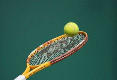 Tennis ball hovering over racket during a match practice