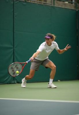 Young athlete practices tennis indoors at training facility