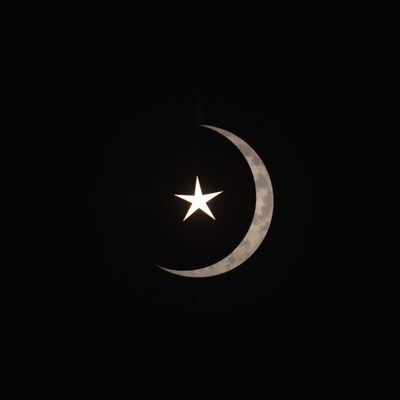 Crescent moon and star shining in a night sky