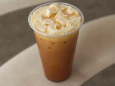 Iced coffee topped with whipped cream in warm setting