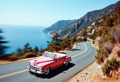 Classic car drives along scenic coastal highway