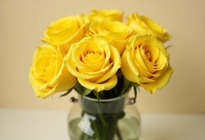 Bright yellow roses arranged in a glass vase