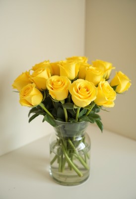 Bright yellow roses in a clear glass vase