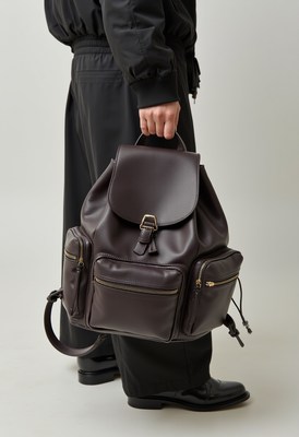 Stylish black backpack held by person in casual outfit