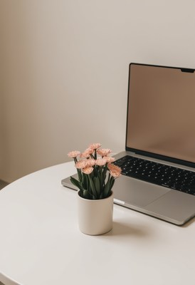 Workspace with laptop and pink flowers on a table
