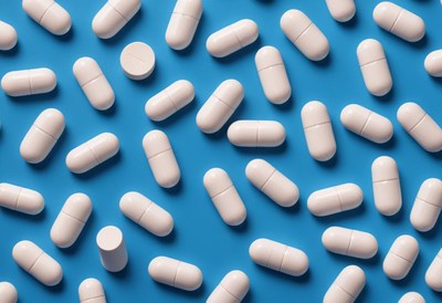 White pills scattered on a light blue surface