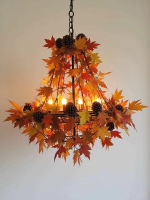 Decorative chandelier with autumn leaves and pinecones