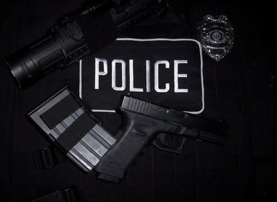 Police gear displayed with a handgun and flashlight