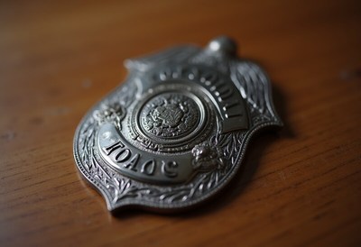 Silver badge resting on a wooden table surface