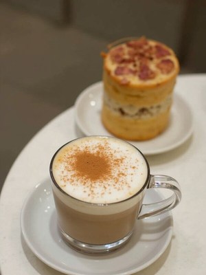 Delicious latte and dessert placement on white table
