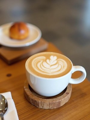 Coffee with latte art and pastry in a cozy cafe setting