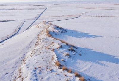Snow-covered hills and plains under clear blue sky