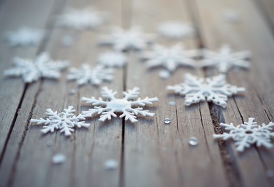Snowflakes resting on a wooden surface in winter light