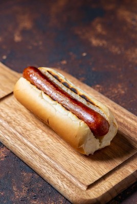 Grilled sausage served on a wooden board at a picnic