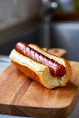 Delicious hot dog served on a wooden cutting board