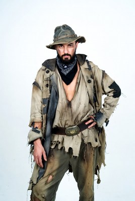 Man dressed in tattered clothes posing for a portrait