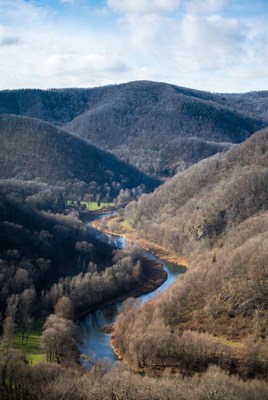 Scenic view of river winding through mountains in winter