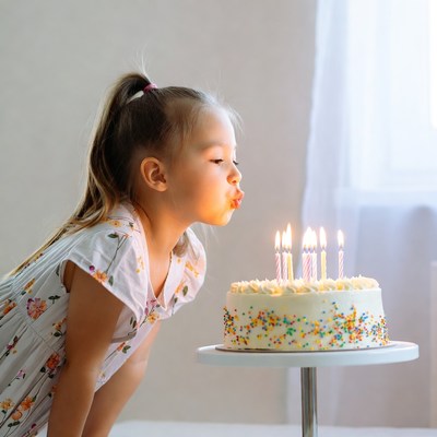 Girl blowing out birthday candles with joy
