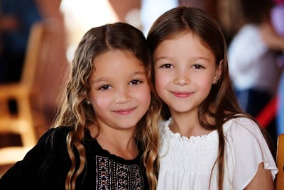 Two young girls smiling together in a cozy setting
