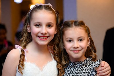 Two young girls smiling at a festive celebration