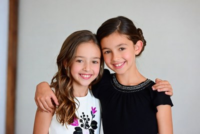 Two young girls smiling and posing together for fun