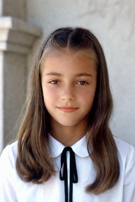 Young girl with long hair and white blouse smiling
