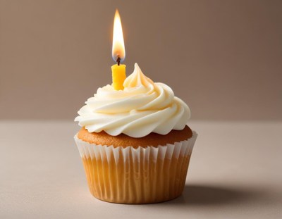Delicious cupcake with a candle on a simple background