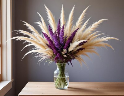 Colorful dried flowers in a glass vase on wooden table