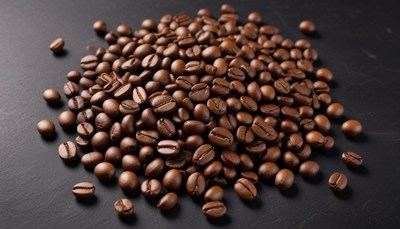 Freshly roasted coffee beans spread across a dark surface