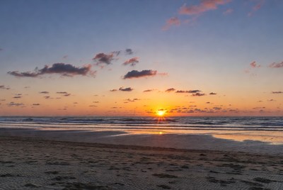 Sunset over calm ocean waves