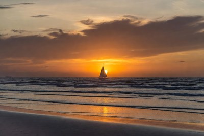Sunset sailboat on ocean waves