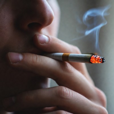 Smoking cigarette with visible ember glow