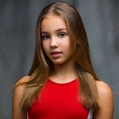 Young gymnast in red outfit posing
