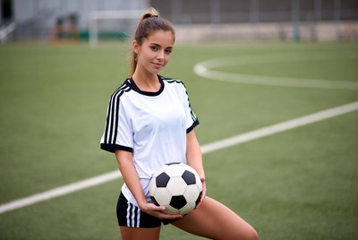 Young woman poses with soccer ball