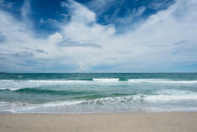 Calm beach under cloudy sky