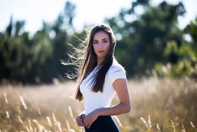 Young woman stands in golden field