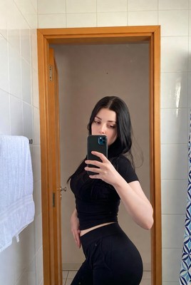 Young woman poses confidently in mirror