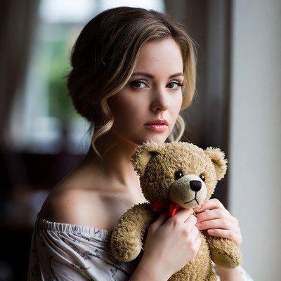 Woman holding teddy bear indoors
