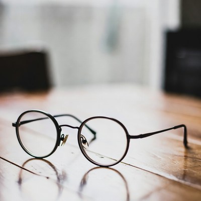 Stylish round glasses on wooden table