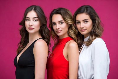 Three women posing against pink background