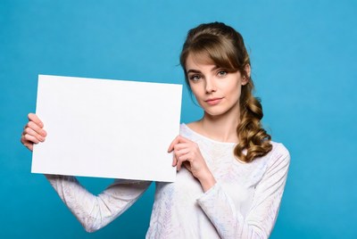Woman holding blank sign on blue background