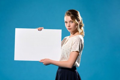 Woman holding blank sign indoors