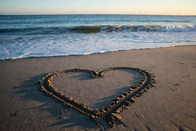 Heart drawing on sandy beach